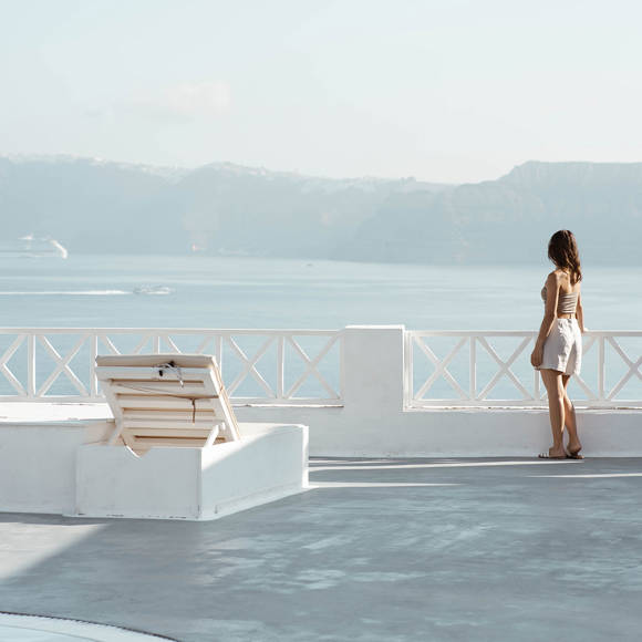 Guest enjoying panoramic Caldera view from the terrace of Santorini View Hotel in Akrotiri