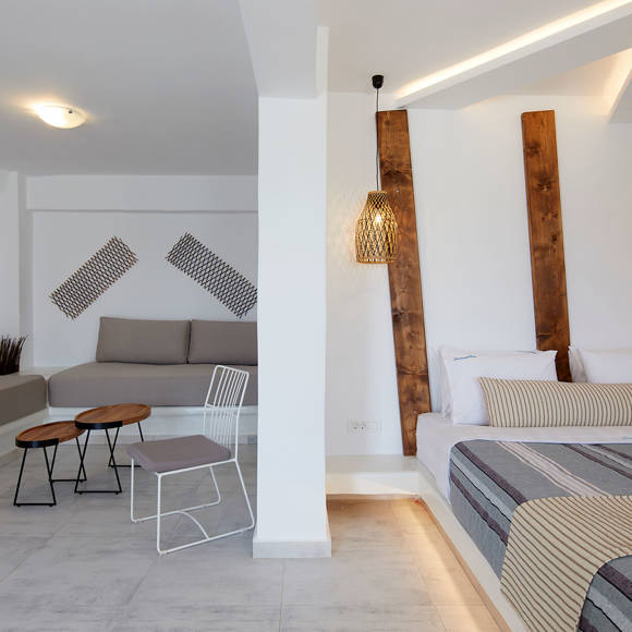 Suite at Santorini View Hotel featuring a modern open-plan layout with seating area, and elegant bedroom decor