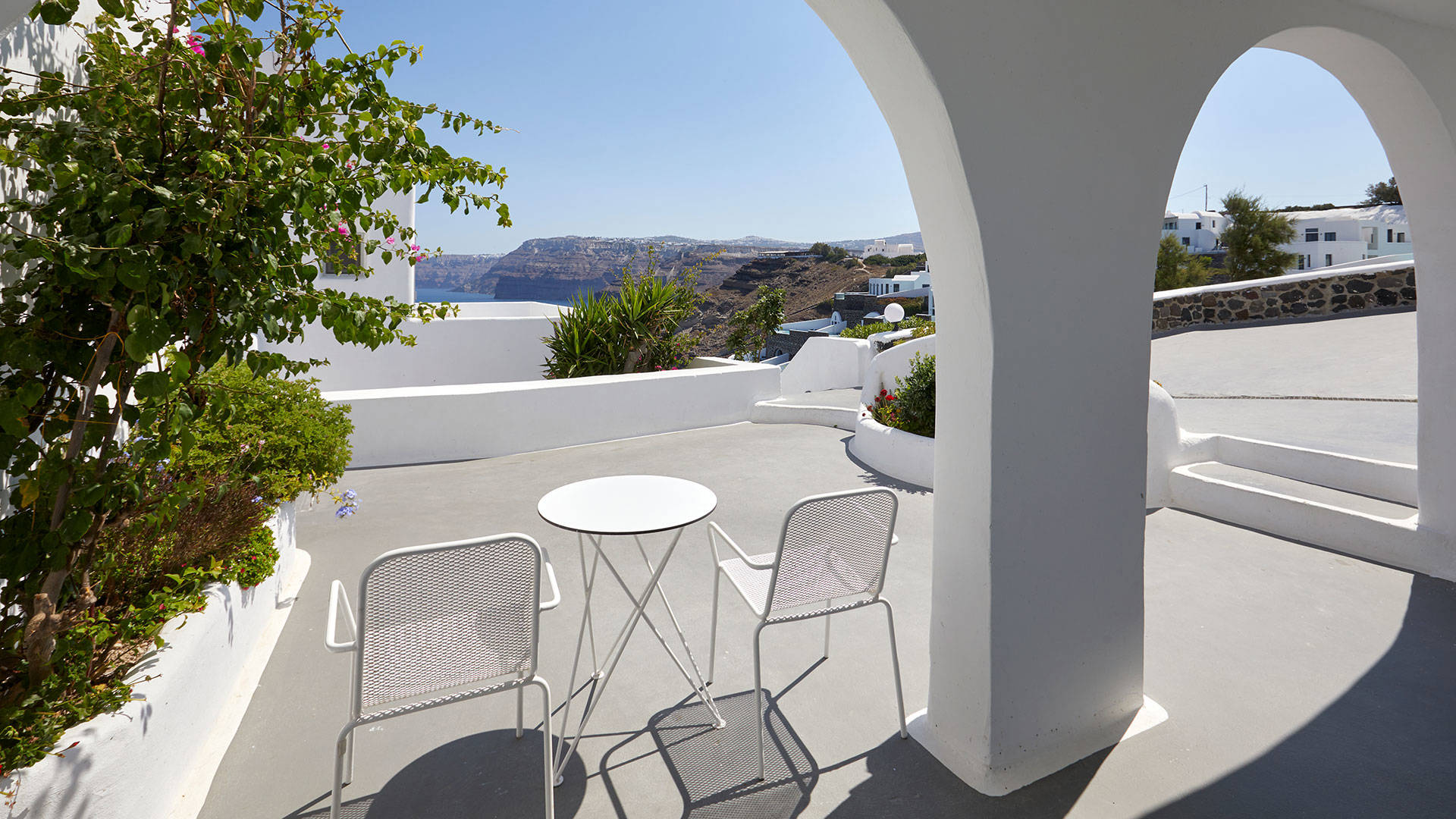 
Santorini View Hotel patio with flowers, table seats and sea view