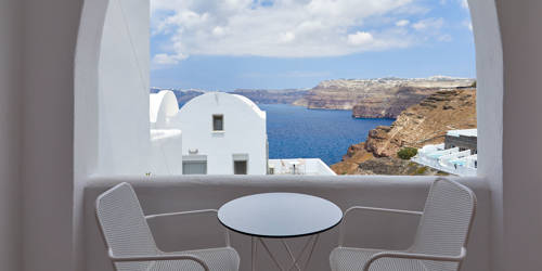 
Santorini View Hotel balcony with sea view and white table seats