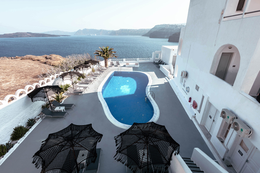 Aerial view of the outdoor swimming pool of Santorini View Hotel overlooking the caldera and the Aegean sea