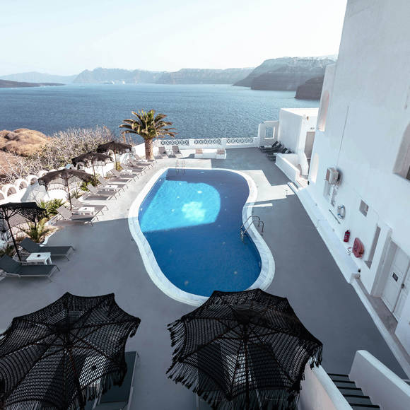 Aerial view of the outdoor swimming pool of Santorini View Hotel overlooking the caldera and the Aegean sea