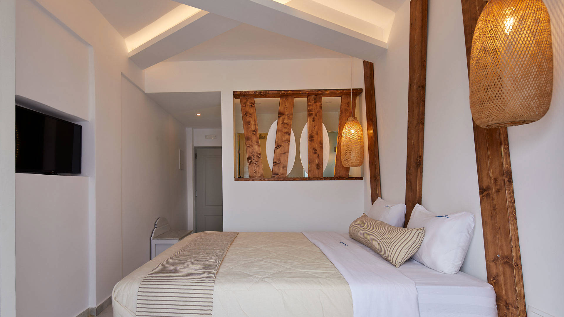 
Santorini View Hotel bedroom with king size bed, tv, wooden decoration and bamboo lights