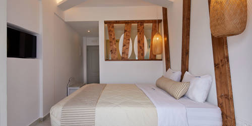 
Santorini View Hotel bedroom with king size bed, tv, wooden decoration and bamboo lights