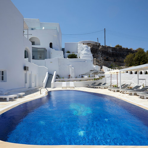  
Ξενοδοχείο με θέα στη Σαντορίνη με λευκά δωμάτια, πισίνα, ξαπλώστρες και πέργκολα
