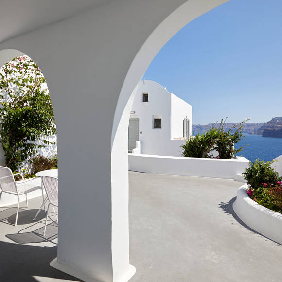 Suite terrace at Santorini View Hotel with elegant arches, whitewashed walls, lush greenery, and caldera sea views