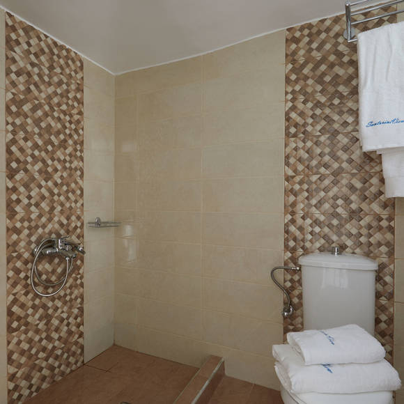 Elegant bathroom in the  Junior Suite at Santorini View Hotel with tiled shower area and fresh white towels
