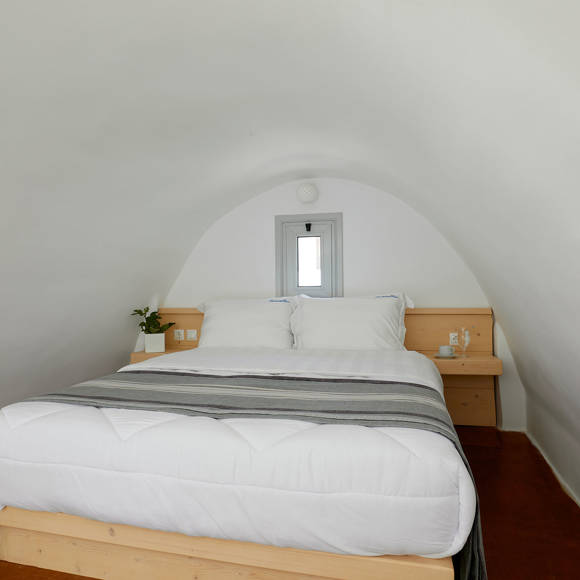 Bright Junior Suite at Santorini View Hotel with arched ceiling, double bed, and natural wooden accents