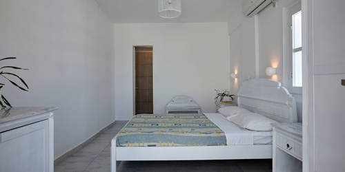 
Santorini View Hotel double bed with colorful linen at a bedroom with white furniture 