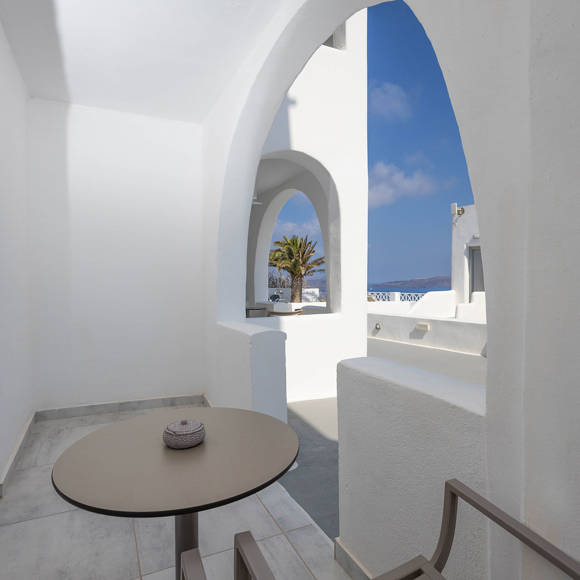 Cozy terrace with arched architecture and seating area outside the Standard Room at Santorini View Hotel