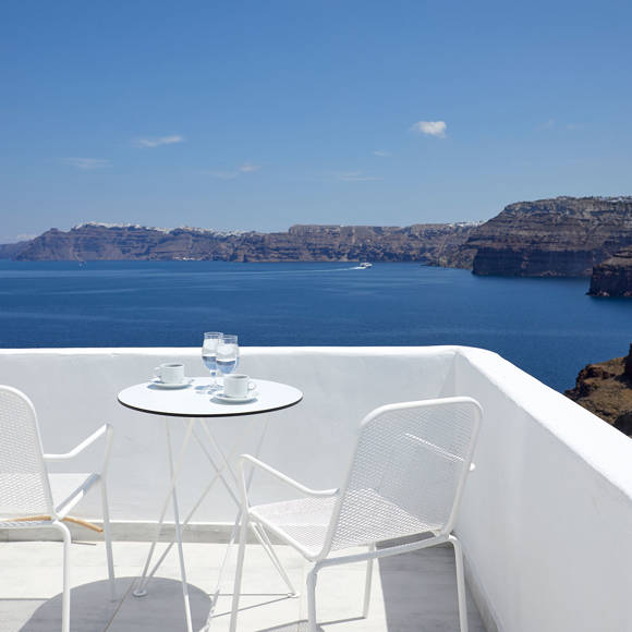 Private balcony of the Junior Suite at Santorini View Hotel with chairs and table overlooking the caldera