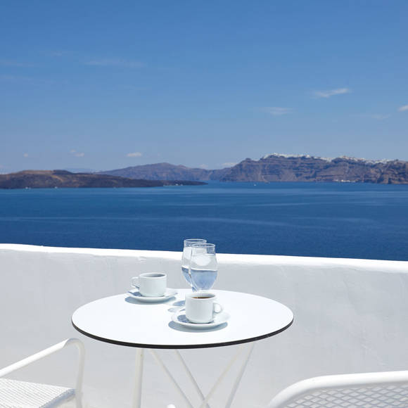 Balcony view from the Junior Suite at Santorini View Hotel with coffee setup overlooking the caldera