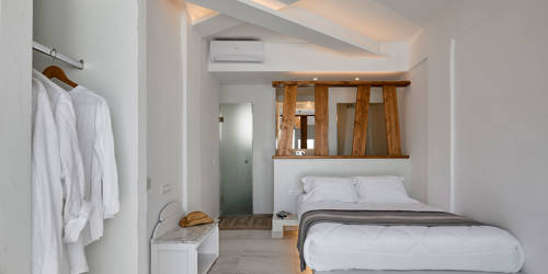 
Santorini View Hotel bedroom with double bed in white linen, wooden decoration and air-condition