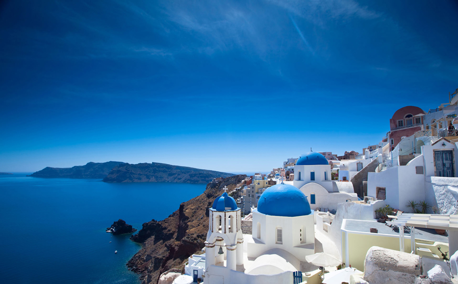 The white houses of the villages stand tall above the caldera, providing a striking contrast against the Aegean