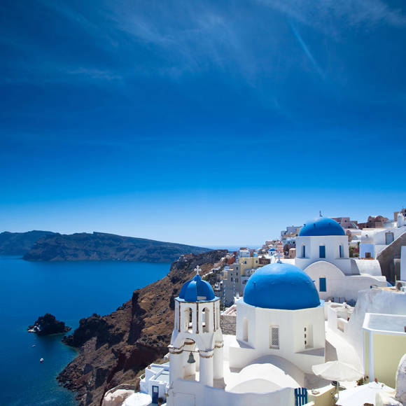The white houses of the villages stand tall above the caldera, providing a striking contrast against the Aegean