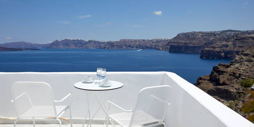 
Santorini View Hotel balcony with caldera view, white table seats, greek coffee and glasses of water