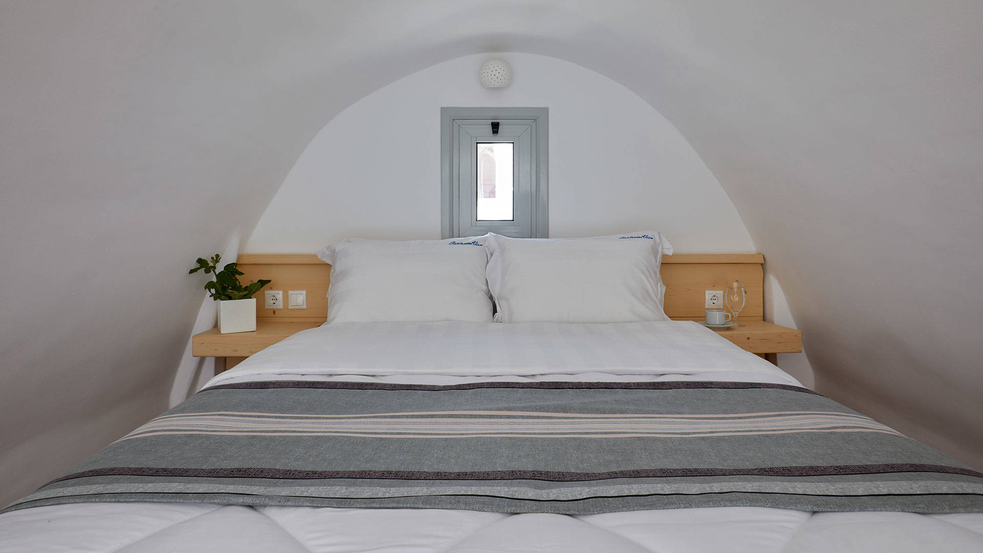 
Santorini View Hotel king size bed with white and grey linen, and window