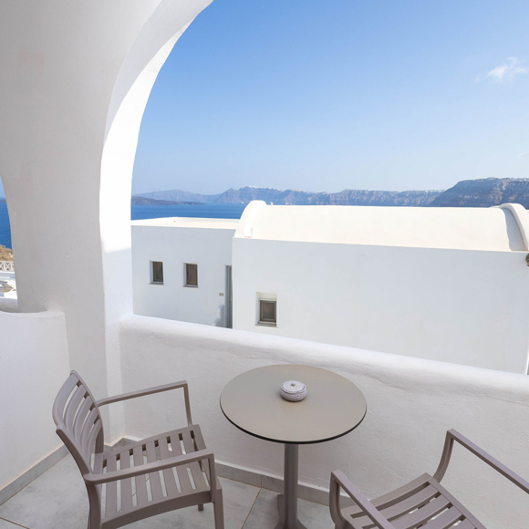 Private balcony of the Standard Room with chairs and table offering a sea view at Santorini View Hotel