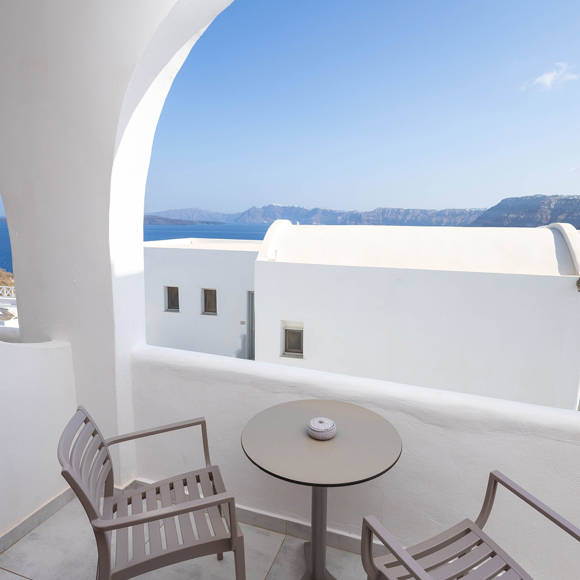 Private balcony of the Standard Room with chairs and table offering a sea view at Santorini View Hotel