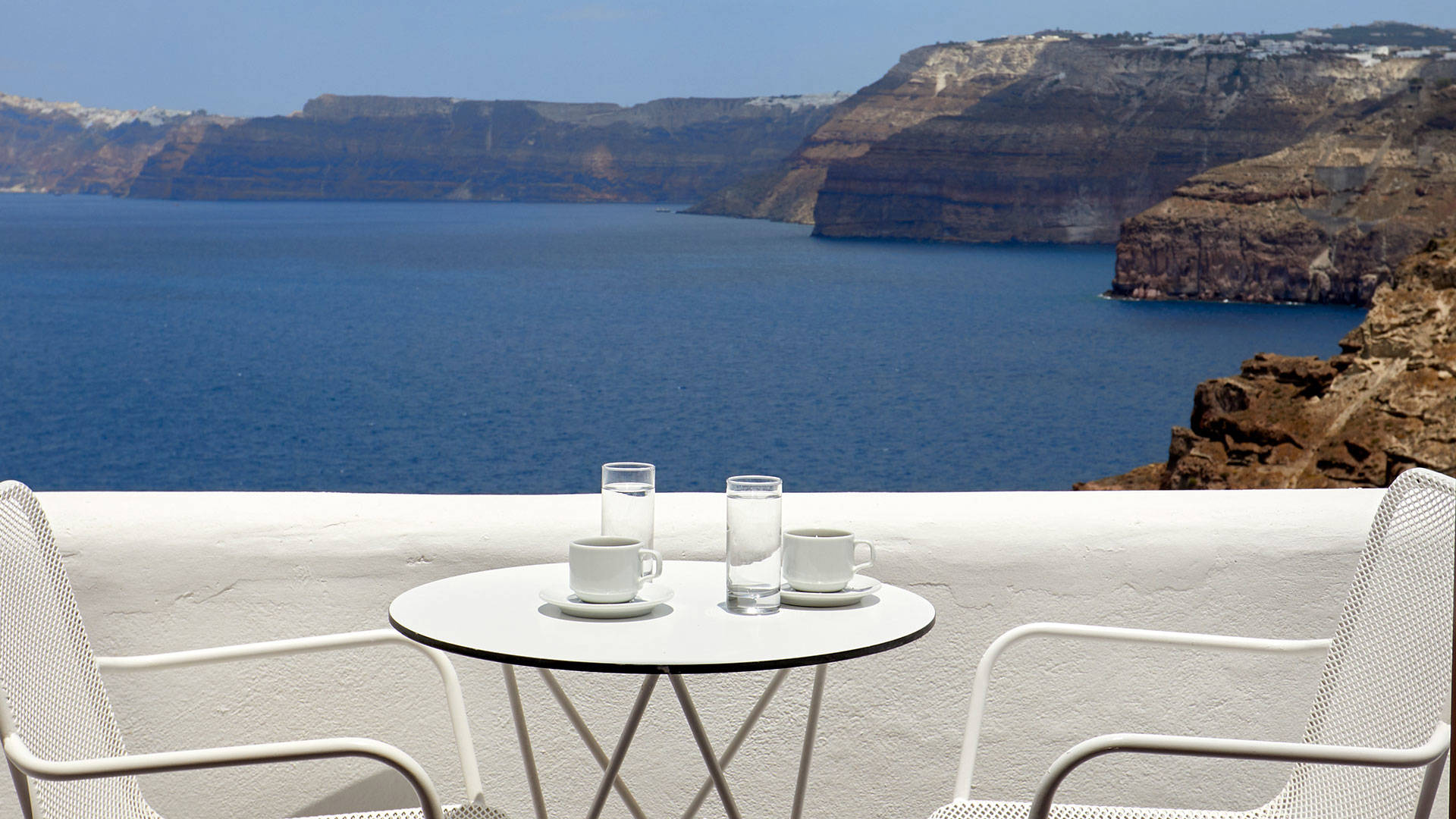 
Santorini View Hotel white table seats at a white balcony with sea view