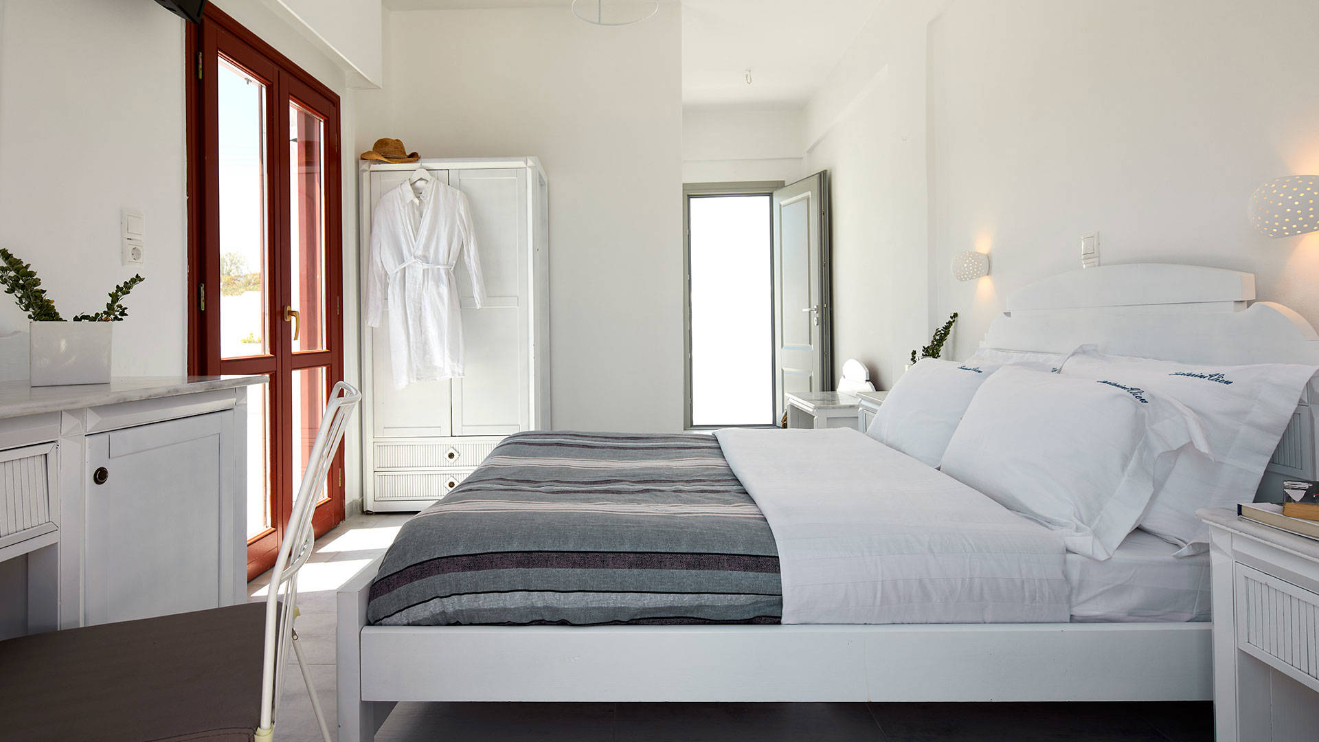 
Santorini View Hotel bedroom with king size bed, bedside table and white closet and furnitures