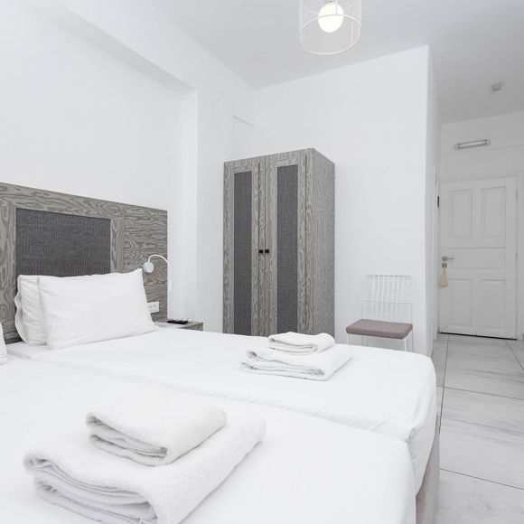 Elegant Standard Room with twin beds and minimalist decor at Santorini View Hotel in Akrotiri