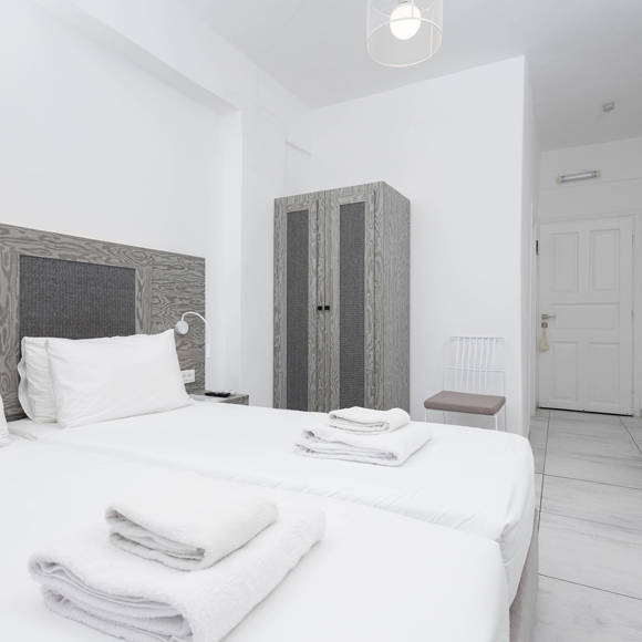 Elegant Standard Room with twin beds and minimalist decor at Santorini View Hotel in Akrotiri