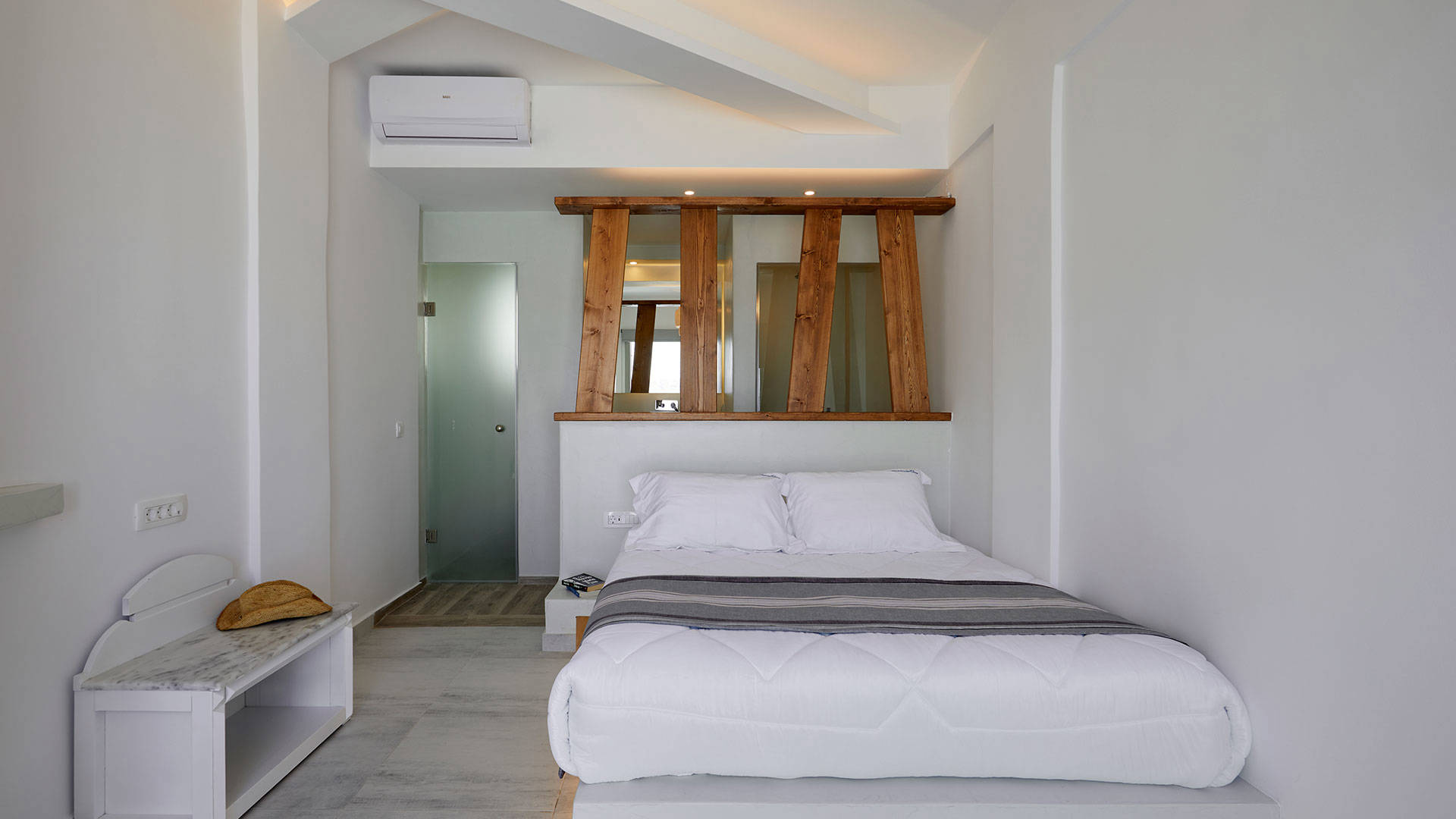 
Santorini View Hotel double bed with white linen and grey coverlet, and wooden decoration