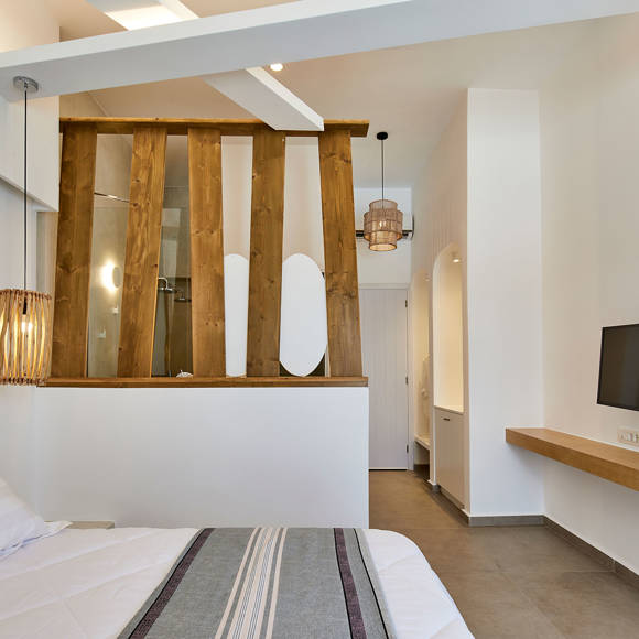 Stylish bedroom of Deluxe double room with modern wooden divider, soft lighting and natural tones