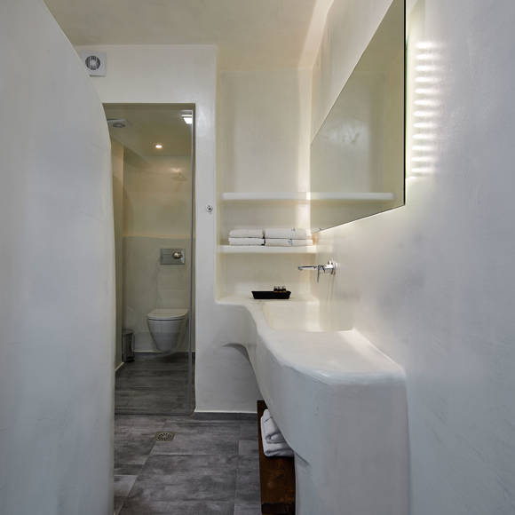 Minimalist bathroom in the Suite at Santorini View Hotel with sculpted white walls, and built-in sink