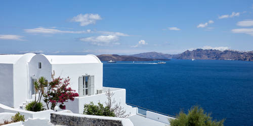 
Santorini View Hotel in white colors, and aegean blue sea with caldera and boats