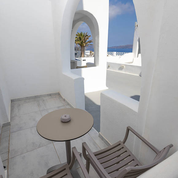Small private balcony with seating area and arched design at Santorini View Hotel Standard Room