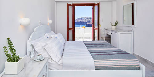 
Santorini View Hotel bedroom with king size bed with striped bed throw, flower pot and balcony with sea view and table seats