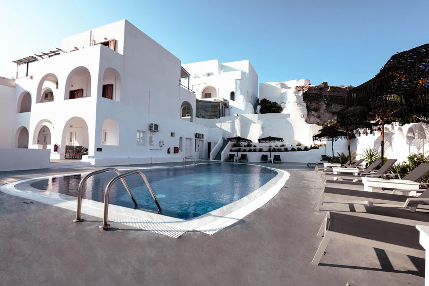 Outdoor swimming pool of Santorini View Hotel surrounded by sun loungers and white Cycladic architecture 