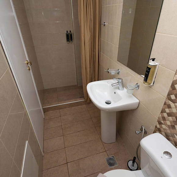 Compact bathroom with shower and modern amenities in the Standard Room at Santorini View Hotel