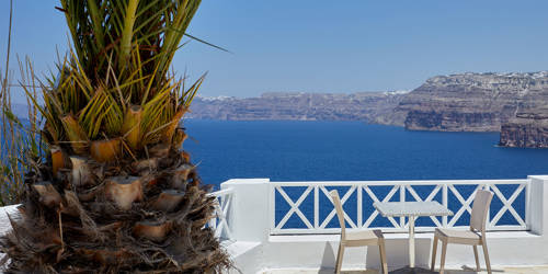 
Santorini View Hotel table seats near a tree, and sea view