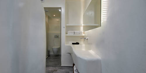
Santorini View Hotel bathroom in white color, a shower, sink and white towels