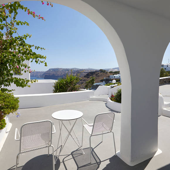 Suite terrace at Santorini View Hotel with arched architecture, outdoor seating, lush plants, and caldera sea view