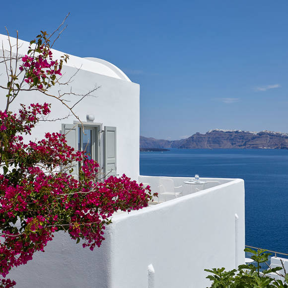 Exterior view of the Junior Suite at Santorini View Hotel, with Cycladic architecture, vibrant bougainvillea and sea view