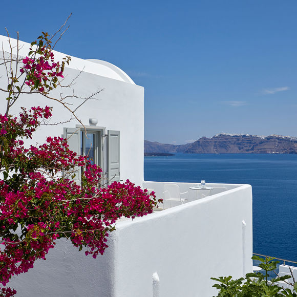 Exterior view of the Junior Suite at Santorini View Hotel, with Cycladic architecture, vibrant bougainvillea and sea view