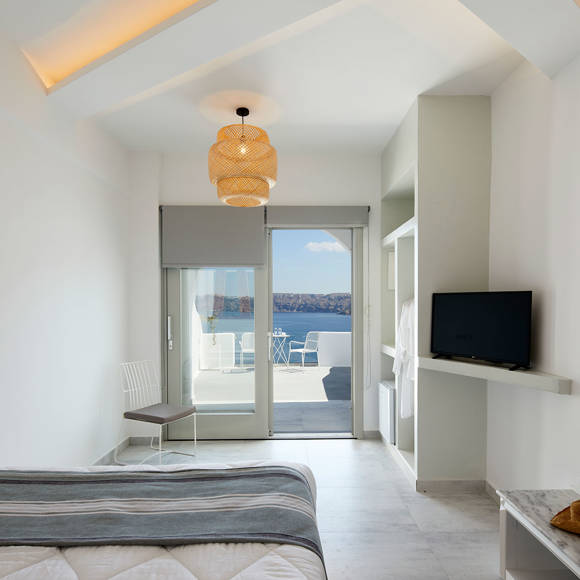 Bright bedroom of Deluxe double room with sea-view terrace, woven ceiling lamp and soft natural light