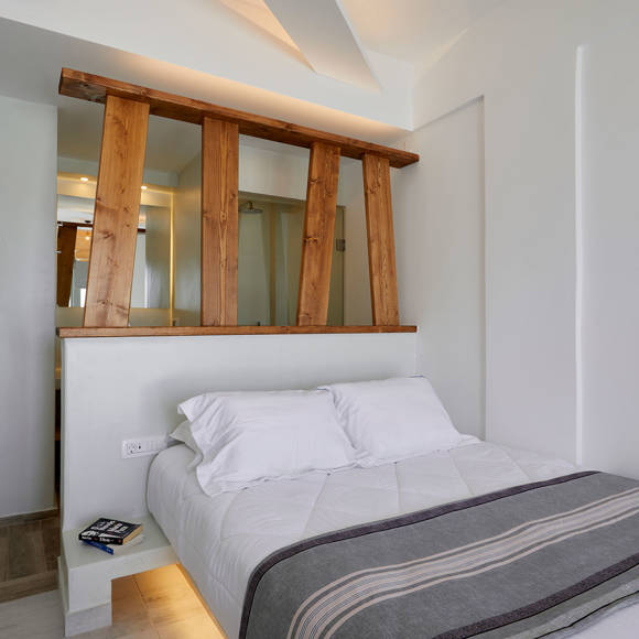 Cozy bedroom of Deluxe Double room with soft lighting, wooden partition and minimalist modern decor