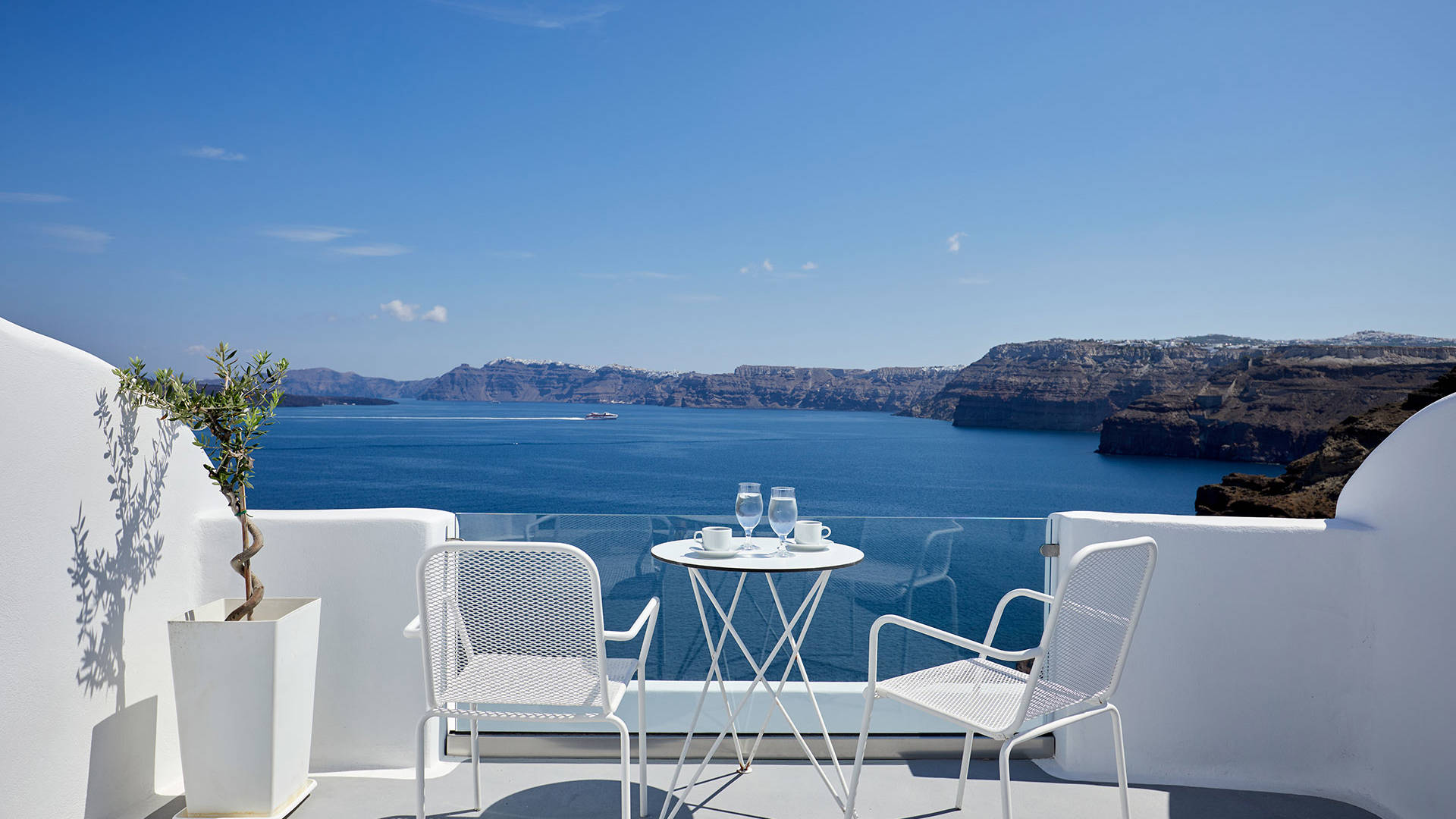 
Santorini View Hotel μπαλκόνι σε λευκά χρώματα με έπιπλα και θέα στο Αιγαίο και την Καλντέρα