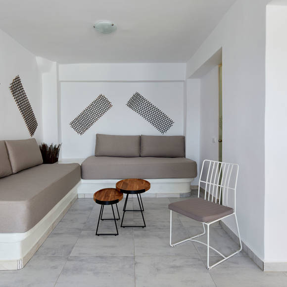 Spacious Suite at Santorini View Hotel with minimalist seating area, modern decor, and neutral tones