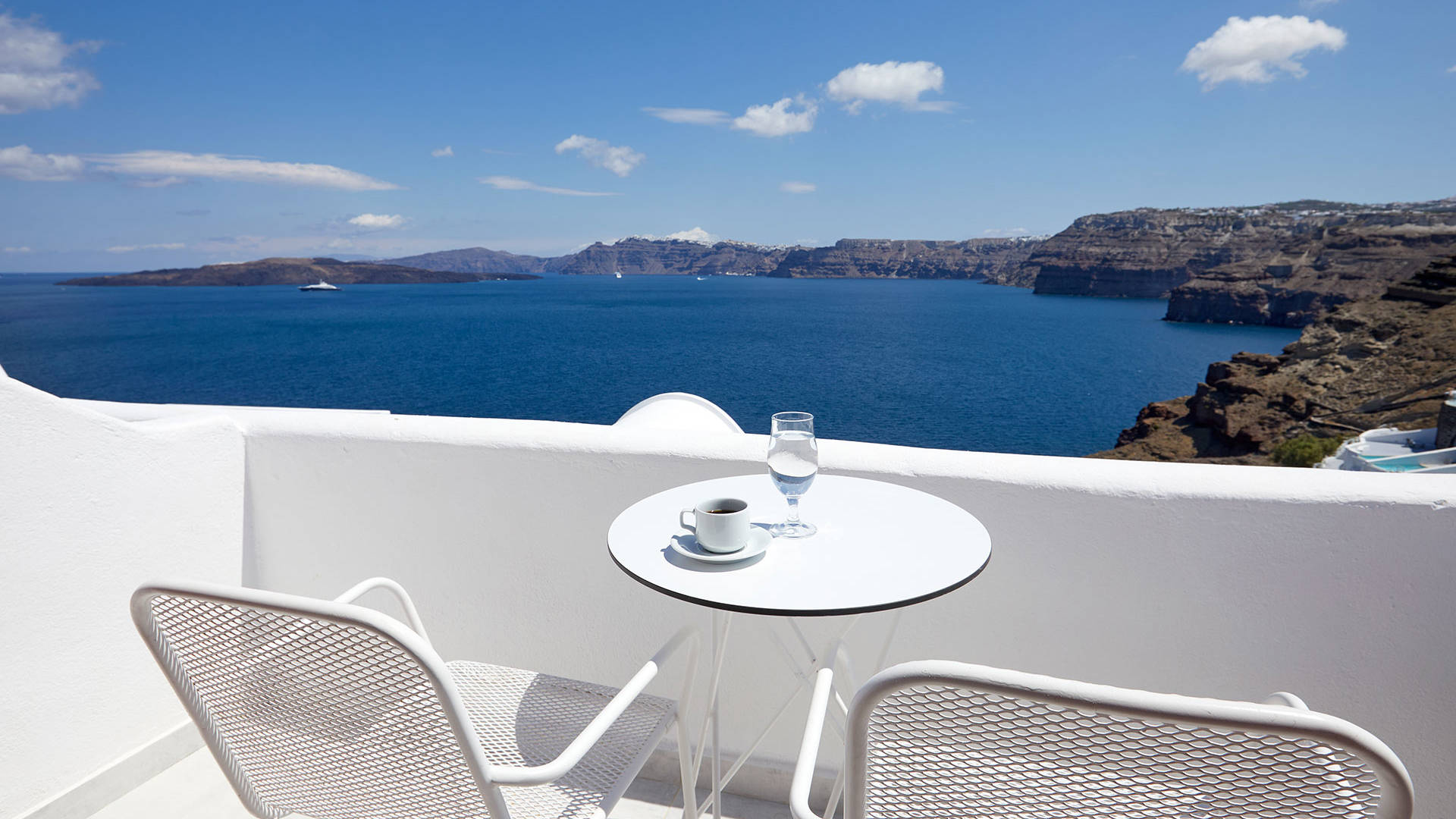 
Santorini View Hotel with a caldera view balcony, with white table for coffee
