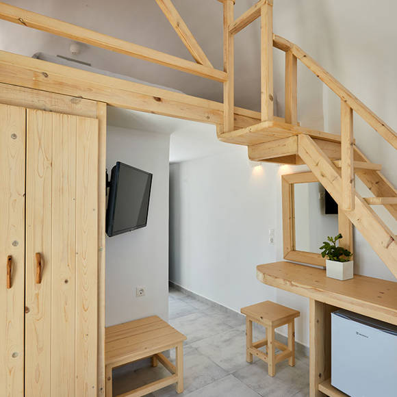 Junior Suite at Santorini View Hotel with wooden loft design, modern furniture, and Cycladic interior style