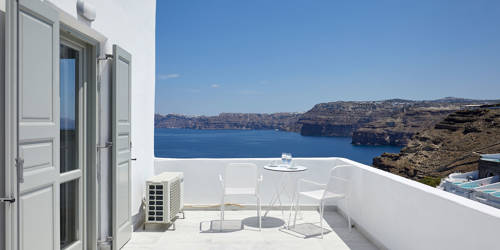 
Santorini View Hotel balcony with white furniture and views to blue sky and aegean sea