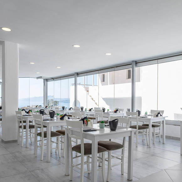 Modern Santorini View Hotel restaurant with white tables, large windows, and sea view