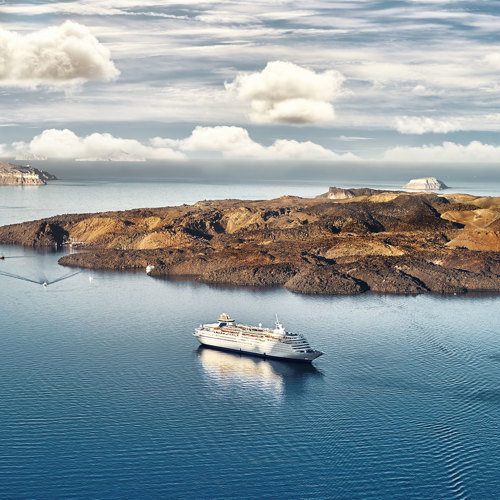  
Panoramic view of mesmerizing Santorini: Infinite blue of the sea meets the lush green craters of the island, creating an unforgettable image.