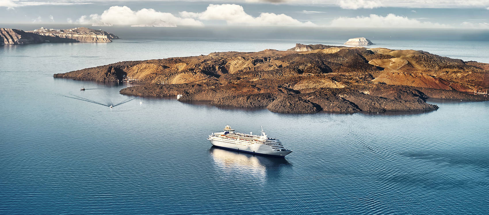 
Panoramic view of mesmerizing Santorini: Infinite blue of the sea meets the lush green craters of the island, creating an unforgettable image.